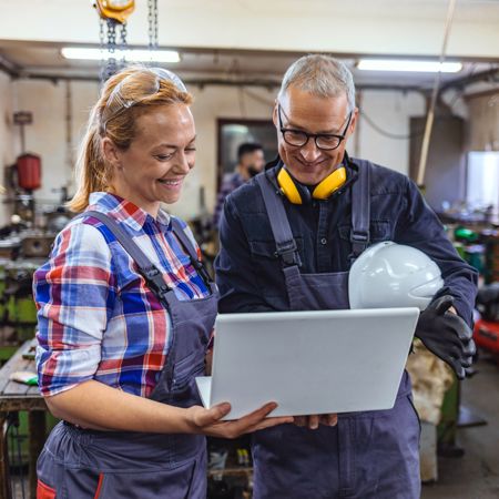 SLIM Leidinggeven - Leidinggevende en medewerker kijken tevreden samen naar beeldscherm
