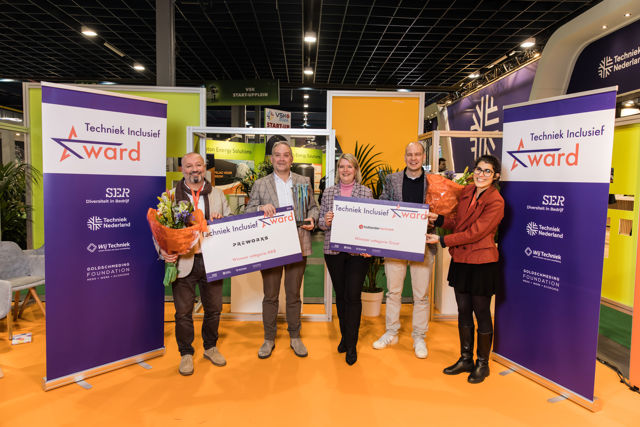 Finalisten Preworxs en Hollander Techniek met prijs en bos bloemen in de hand voor grote banners met logo Techniek Inclusief Award. Twee mannen en twee vrouwen kijken lachend in de camera.